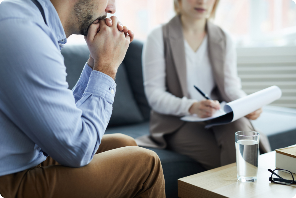 A calming therapy office setting with comfortable chairs, warm lighting, suggesting a safe space for healing. 